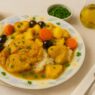 AIP Moroccan Chicken Tagine served with rice, carrots, potatoes, olives, and fresh parsley in a rich turmeric sauce on a floral plate – gluten-free, dairy-free, anti-inflammatory, autoimmune-friendly dish.