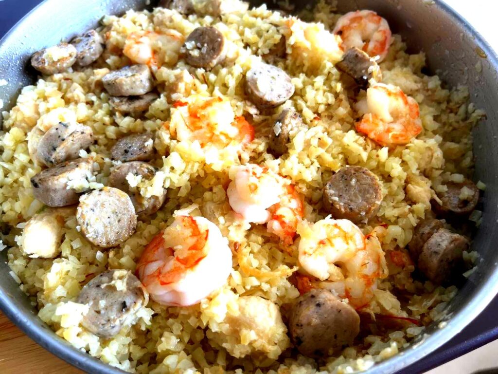 A nourishing AIP Chicken Paella, a grain-free Mediterranean dish with cauliflower rice, chicken, fresh vegetables, and anti-inflammatory herbs, served in a rustic bowl.