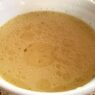 A bowl of AIP chicken bone broth with vegetables, a nutritious, collagen-rich drink for gut health and inflammation relief