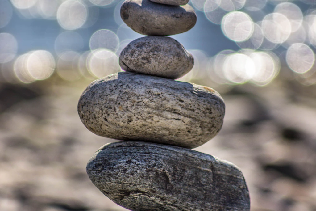 Four stones stacked on top of each other, symbolizing balance and strength in the AIP journey lifestyle.