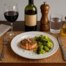 Bacon-wrapped pork chops with broccoli on a white plate, gluten-free and dairy-free meal for an autoimmune-friendly, nutrient-dense diet.