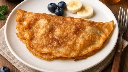 Blueberries, banana crepes on a plate with fresh fruit and honey, AIP, gluten-free, dairy-free, autoimmune-friendly dessert.