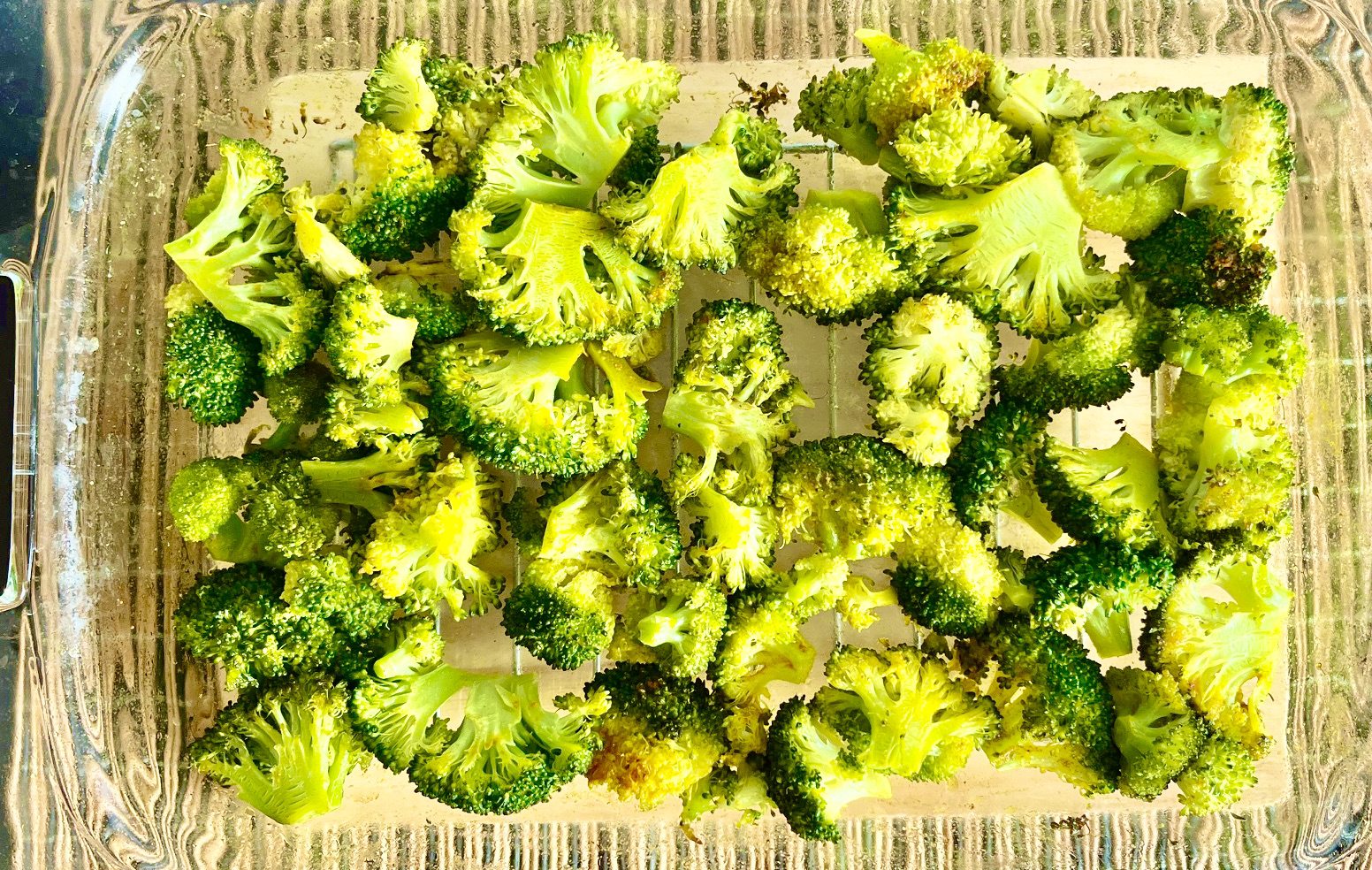 Roasted garlic turmeric broccoli, perfectly crisped and golden, ready to be served alongside bacon-wrapped pork chops.