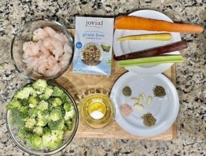 Ingredients for Garlic Shrimp Cassava Orzo, including shrimp, carrots, celery, broccoli, cassava orzo, garlic, avocado oil, thyme, oregano, and parsley.