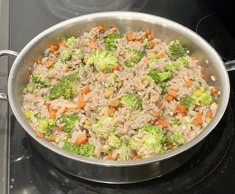 Cassava orzo mixed with sautéed carrots, celery, and broccoli in a skillet, the final step of the AIP-friendly Garlic Shrimp Cassava Orzo