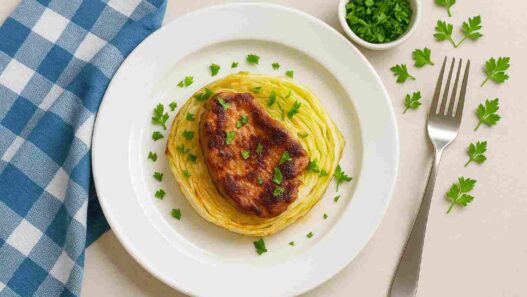 AIP Pork and Cabbage Steaks served on a white plate with fresh parsley, gluten-free, dairy-free, nutrient-dense AIP dinner, perfect for autoimmune diet recipes.