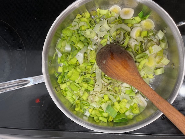 Sautéing leeks in a pan, cooking until tender, to be used as a savory filling for AIP-friendly sweet potato cups in this gluten-free, egg-free AIP recipe.