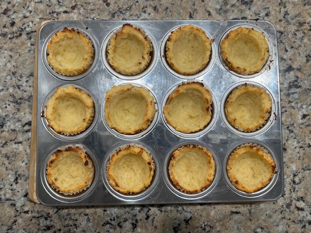 Baked AIP-friendly sweet potato cups, golden and crisp, ready to be filled with sautéed leeks and topped with cranberry sauce for a healthy, gluten-free, egg-free appetizer.