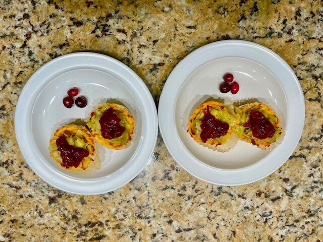 A plate of finished AIP-friendly sweet potato cups, filled with sautéed leeks and topped with homemade cranberry sauce, a healthy and gluten-free appetizer