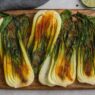 Roasted Bok Choy with turmeric and spices on wooden board – anti-inflammatory, gluten-free, nutrient-dense, AIP-friendly vegetable side dish.
