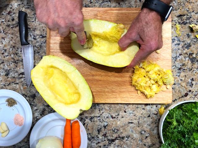 Halved spaghetti squash with seeds being removed, ready to be roasted for a nourishing Spaghetti Squash Bowl, AIP-friendly and gluten-free.