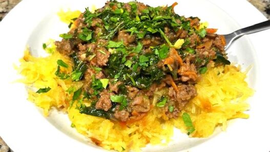 A Spaghetti Squash Bowl featuring roasted spaghetti squash strands topped with savory ground beef, sautéed vegetables, and wilted kale, garnished with fresh parsley. Perfect for AIP, Paleo, and gluten-free lifestyles.