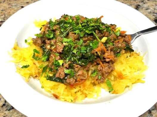 A Spaghetti Squash Bowl featuring roasted spaghetti squash strands topped with savory ground beef, sautéed vegetables, and wilted kale, garnished with fresh parsley. Perfect for AIP, Paleo, and gluten-free lifestyles.