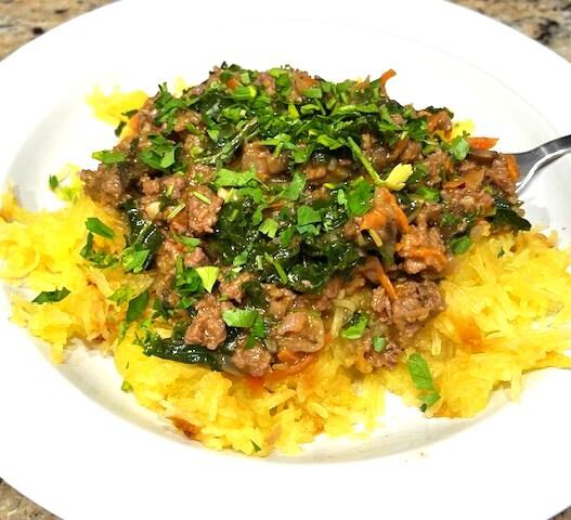 A Spaghetti Squash Bowl featuring roasted spaghetti squash strands topped with savory ground beef, sautéed vegetables, and wilted kale, garnished with fresh parsley. Perfect for AIP, Paleo, and gluten-free lifestyles.