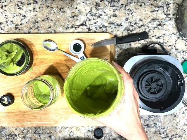 Creamy Avocado Kale Dressing - Pouring this AIP-compliant, healthy, and dairy-free dressing into a jar, ready to enjoy.