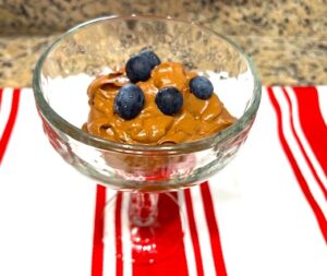 Creamy Cacao Avocado Pudding in a glass cup with fresh blueberries on top, gluten-free, dairy-free, nut-free, and nightshade-free.