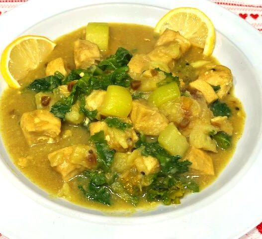 Cardamom-infused Mahi-Mahi Curry on a plate with sweet potatoes, zucchini, carrots, kale, and fresh cilantro garnish.