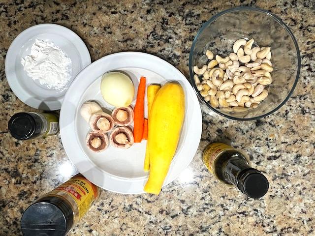 Ingredients for cashew veggie meatballs, including zucchini, carrot, mushrooms, cashews, tapioca flour, coconut aminos, and seasonings.