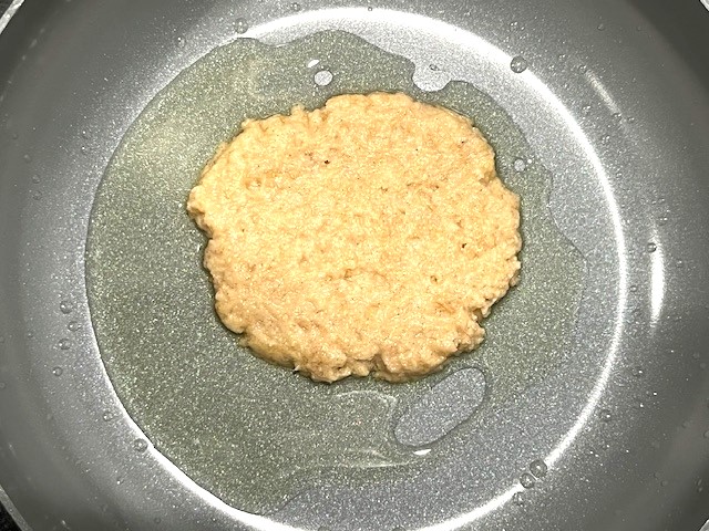 A pancake cooking in a skillet, part of Delicious AIP Banana Pancakes, gluten-free, dairy-free, and AIP-compliant.