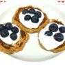 Three Delicious AIP Banana Pancakes topped with coconut yogurt and fresh blueberries on a white plate. A perfect gluten-free, dairy-free, and healthy breakfast!