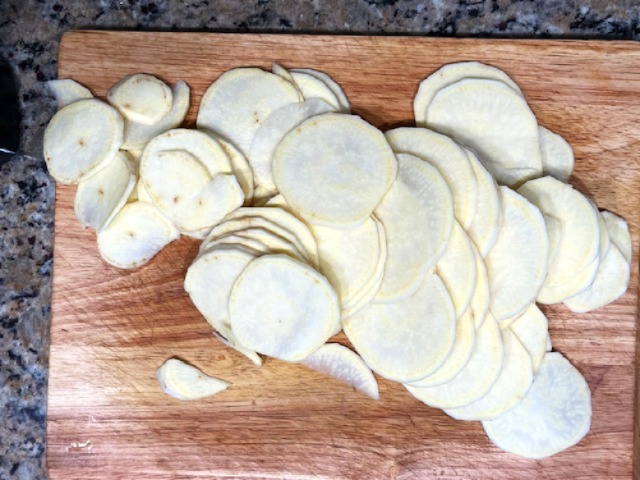 Thinly sliced sweet potatoes prepared for an AIP Reintroduction Garlic Shrimp and Sweet Potato Gratin, a gluten-free, nightshade-free dish ideal for autoimmune-friendly diets.