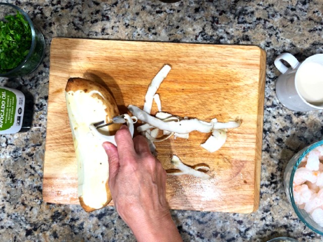 Peeling sweet potatoes for an AIP Reintroduction recipe, a gluten-free and nightshade-free gratin made with sweet potatoes, shrimp, and a creamy coconut milk sauce.