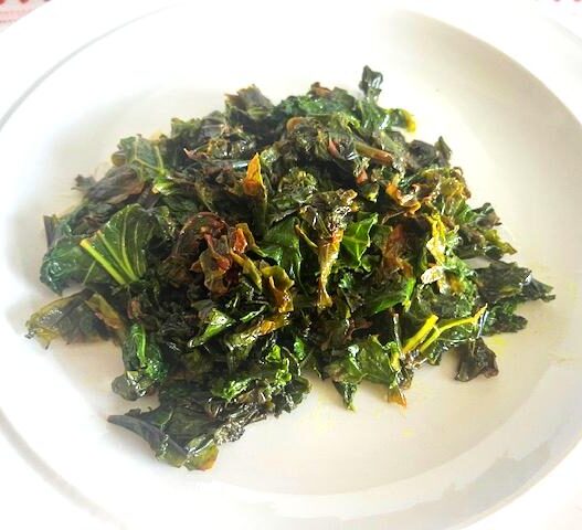 Kale Sautéed with Cumin and Ghee served on a white plate, garnished with lemon juice.