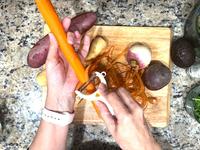 Peeling fresh carrots for Lettuce & Roasted Root Veggies Salad – a gluten-free, dairy-free, AIP-friendly recipe packed with nutrients.