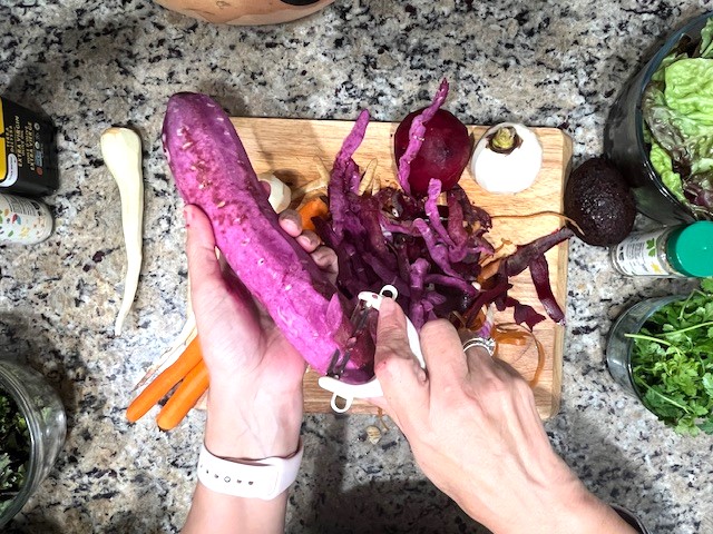 Peeling sweet potatoes for Lettuce & Roasted Root Veggies Salad – a gluten-free, dairy-free, AIP-friendly recipe full of nutrients.