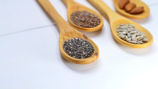 Nuts and seeds arranged on wooden spoons, including almonds, pumpkin seeds, and sunflower seeds.