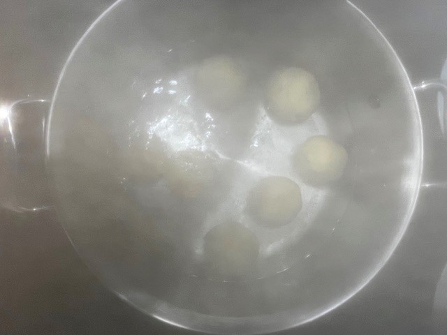 Boiling AIP-Friendly Plum Dumplings in water. A gluten, dairy, nut, and nightshade-free dessert, perfect for egg reintroduction on the Autoimmune Diet.