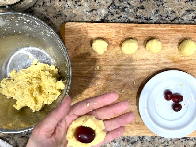 Shaping the AIP-Friendly Plum Dumplings, wrapping dough around plums. A gluten, dairy, nut, and nightshade-free treat, perfect for egg reintroduction on the Autoimmune Diet.