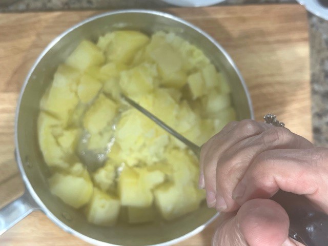 Mashing sweet potatoes for AIP-Friendly Plum Dumplings. A key step to creating a smooth dough for a gluten, dairy, nut, and nightshade-free dessert suitable for egg reintroduction.