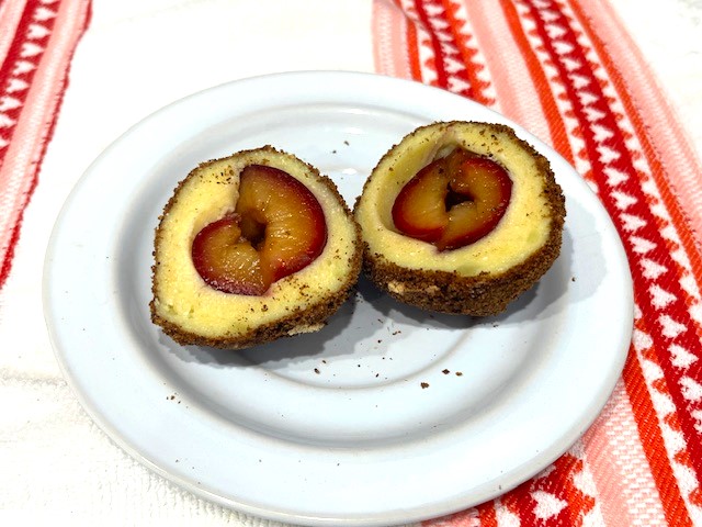 Two halves of an AIP-Friendly Plum Dumpling on a plate, revealing the soft filling. A gluten, dairy, nut, and nightshade-free dessert, perfect for egg reintroduction on the Autoimmune Diet.