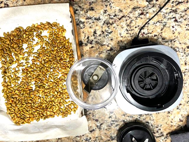 Roasted pumpkin seeds cooling on a baking tray, ready to be blended into creamy Pumpkin Seed Butter.