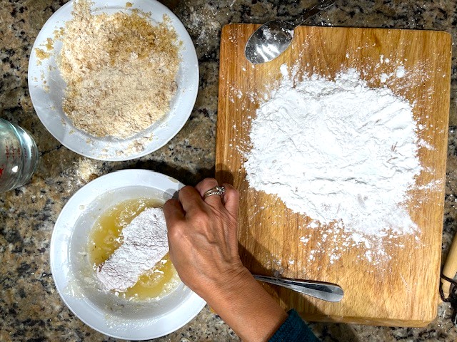 Coating a chicken breast with gelatin egg after tapioca flour for the Tastiest Chicken Breast Schnitzel, a gluten-free, dairy-free, egg-free recipe.