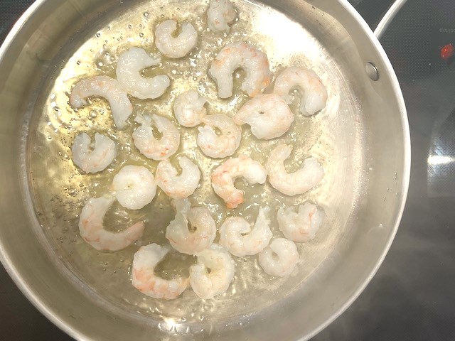 Cooking shrimp in a skillet for Shrimp and Veggie Pasta, a flavorful AIP Reintroduction, gluten-free, and dairy-free recipe.