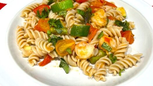 Shrimp and Veggie Pasta served on a white plate, featuring zucchini, asparagus, cherry tomatoes, and gluten-free pasta. An AIP Reintroduction, gluten-free, dairy-free meal packed with fresh vegetables.