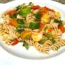 Shrimp and Veggie Pasta served on a white plate, featuring zucchini, asparagus, cherry tomatoes, and gluten-free pasta. An AIP Reintroduction, gluten-free, dairy-free meal packed with fresh vegetables.