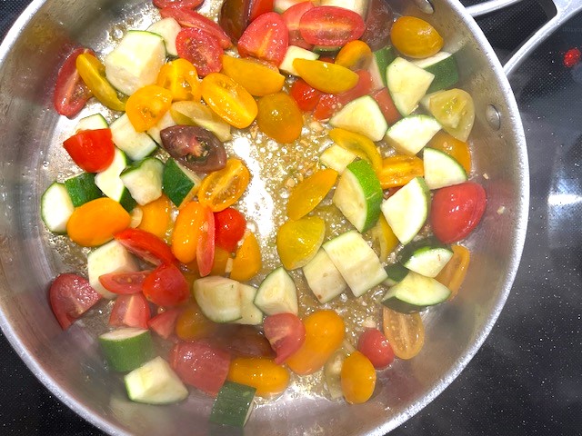 Sautéing zucchini, asparagus, and cherry tomatoes in a pan for Shrimp and Veggie Pasta, a gluten-free, dairy-free, AIP Reintroduction recipe.