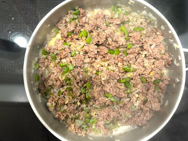 Cooking ground meat with sautéed vegetables in a pan for Savory Stuffed Butternut Squash. AIP reintroduction, gluten-free, dairy-free recipe.