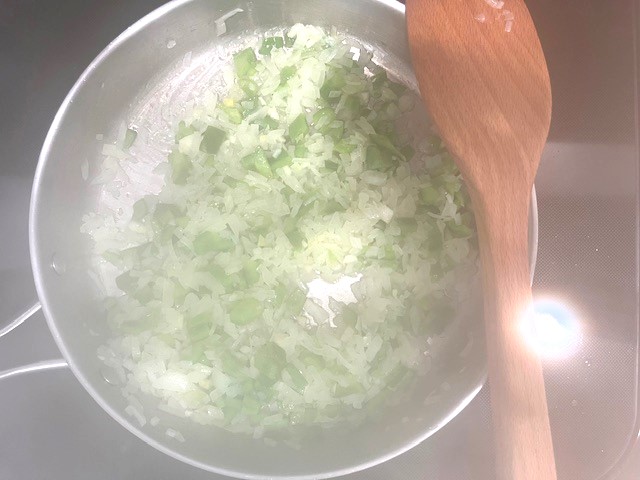 Sautéing vegetables in a pan, including onions, green pepper, and garlic, for Savory Stuffed Butternut Squash. AIP reintroduction, gluten-free, dairy-free recipe.