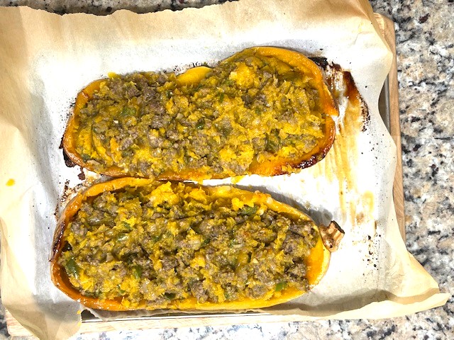 Stuffed butternut squash ready to be baked, filled with a mixture of squash flesh, ground meat, and vegetables. AIP reintroduction, gluten-free, dairy-free recipe.