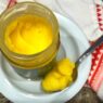 A jar of ghee on a wooden countertop, ideal for Recipes with Ghee in the AIP Reintroduction Phase