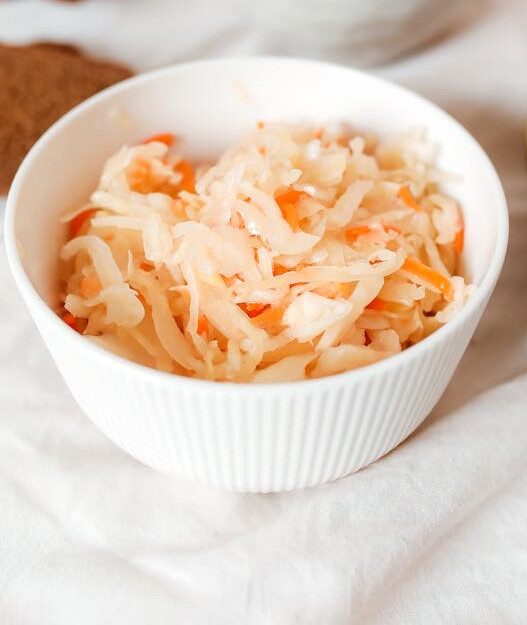 Homemade AIP Sauerkraut in a bowl, made with cabbage, carrots, and garlic, a probiotic-rich dish for gut health.