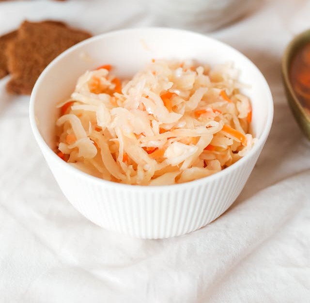 Homemade AIP Sauerkraut in a bowl, made with cabbage, carrots, and garlic, a probiotic-rich dish for gut health.