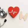 Hashimoto’s and Heart Health connection illustrated by a stethoscope, red heart with ECG line, and thyroid shape on a neutral background
