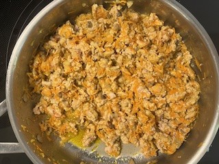 Stuffed portobello mushrooms filling in a skillet, made with ground turkey, shredded carrots, and AIP seasonings
