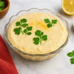 AIP Cauliflower Butternut Hummus in a glass bowl with parsley garnish, creamy chickpea-free dip on a stone countertop, AIP elimination, gluten-free, legumes-free, dairy-free, nightshades-free