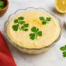 AIP Cauliflower Butternut Hummus in a glass bowl with parsley garnish, creamy chickpea-free dip on a stone countertop, AIP elimination, gluten-free, legumes-free, dairy-free, nightshades-free